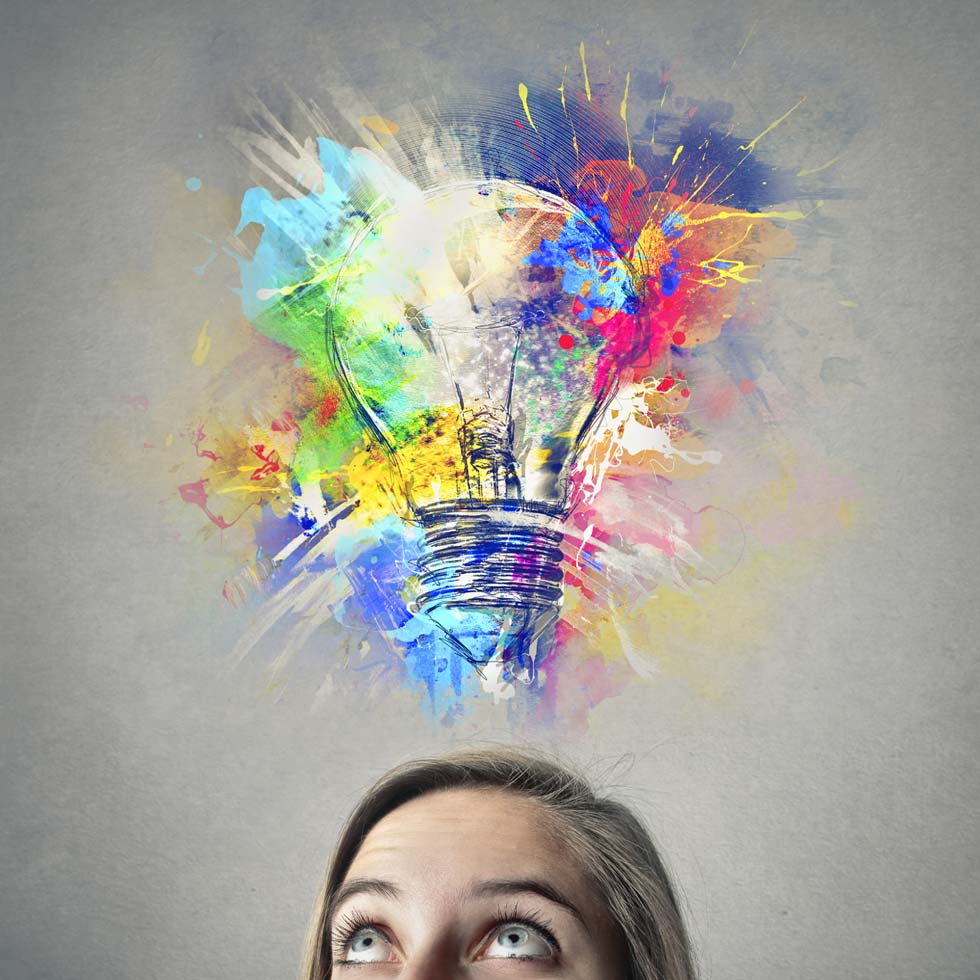 Woman with bright idea showing a light bulb and lots of color splashes